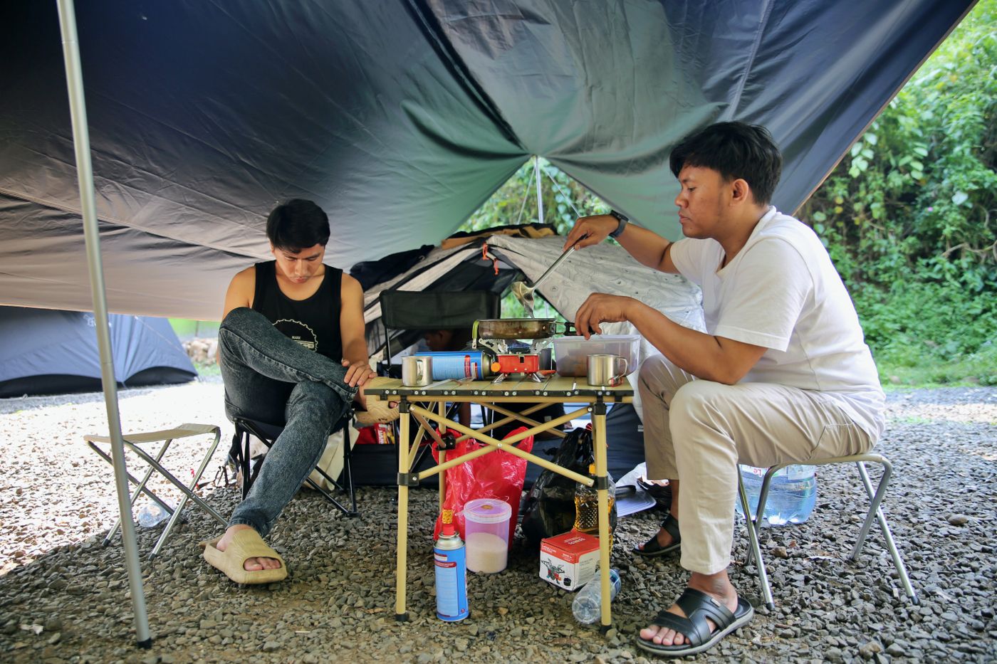 Campers preparing food under a shelter